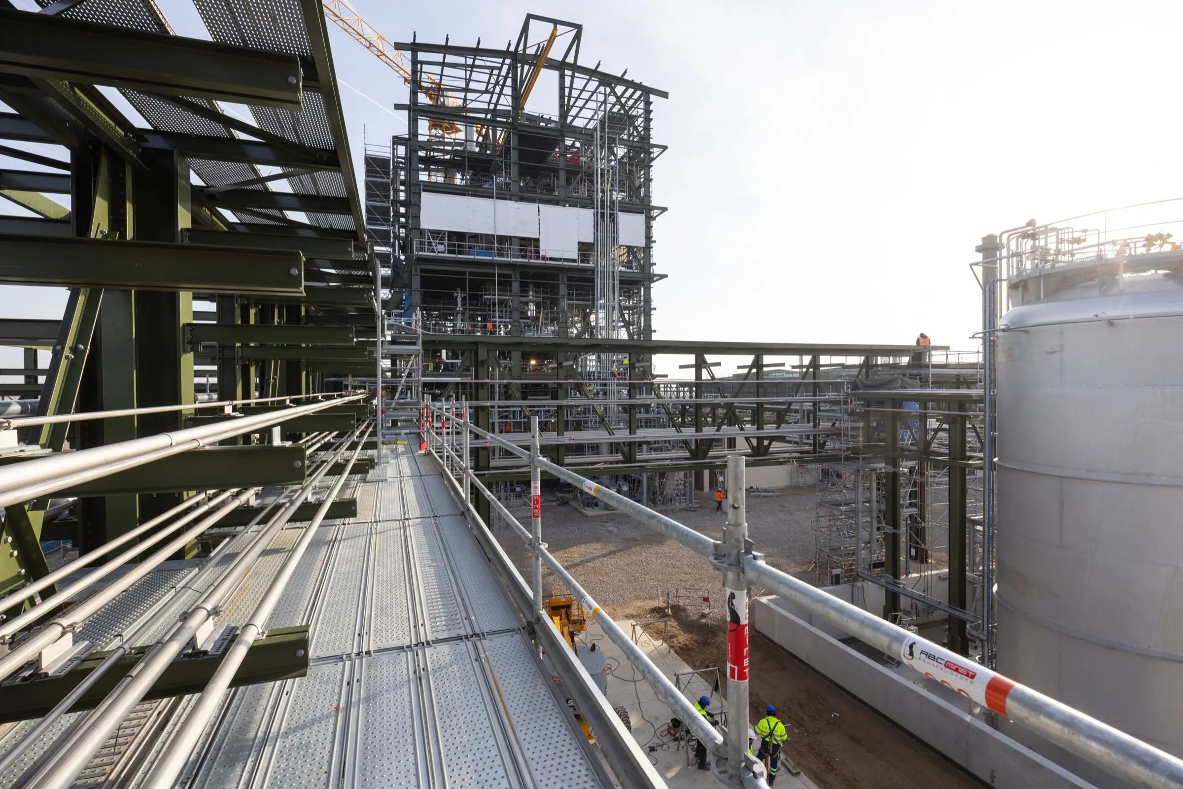 Chantier industriel avec échafaudages complexes et cuves de stockage