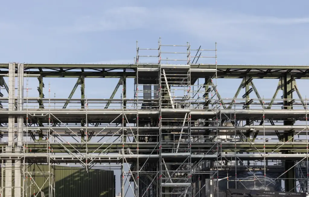 Structure d'échafaudage de grande envergure supportant des réseaux de tuyauterie industrielle