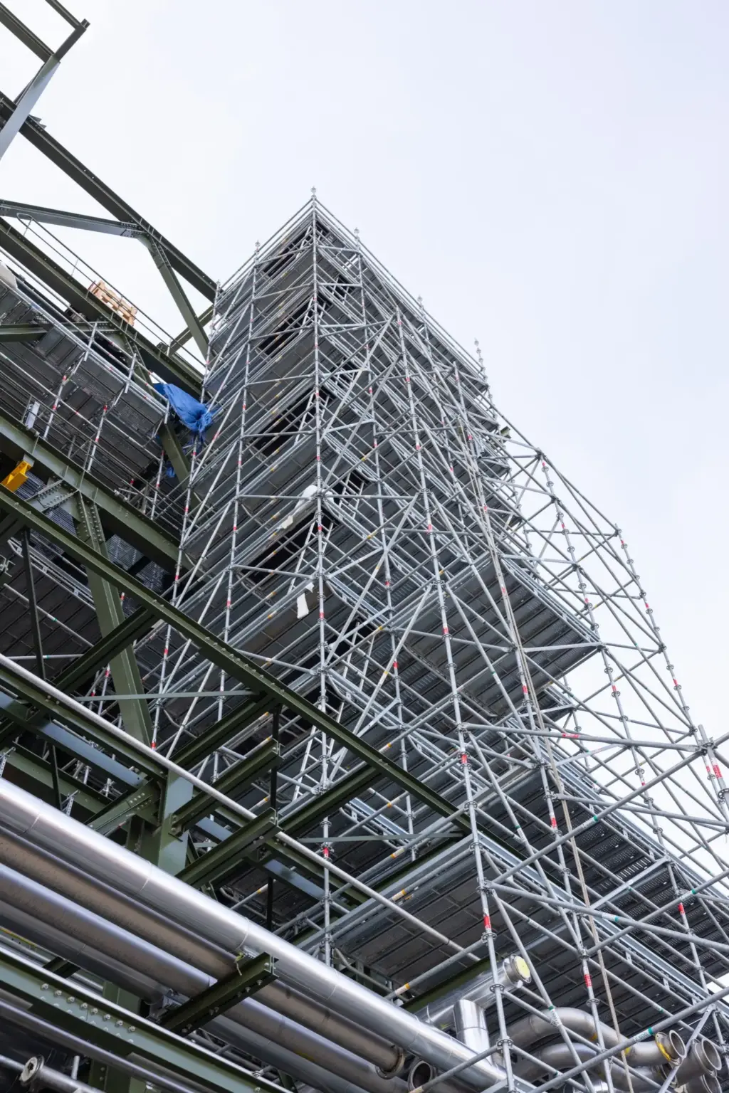 Vue en contre-plongée d'un échafaudage industriel soulignant la verticalité et la complexité