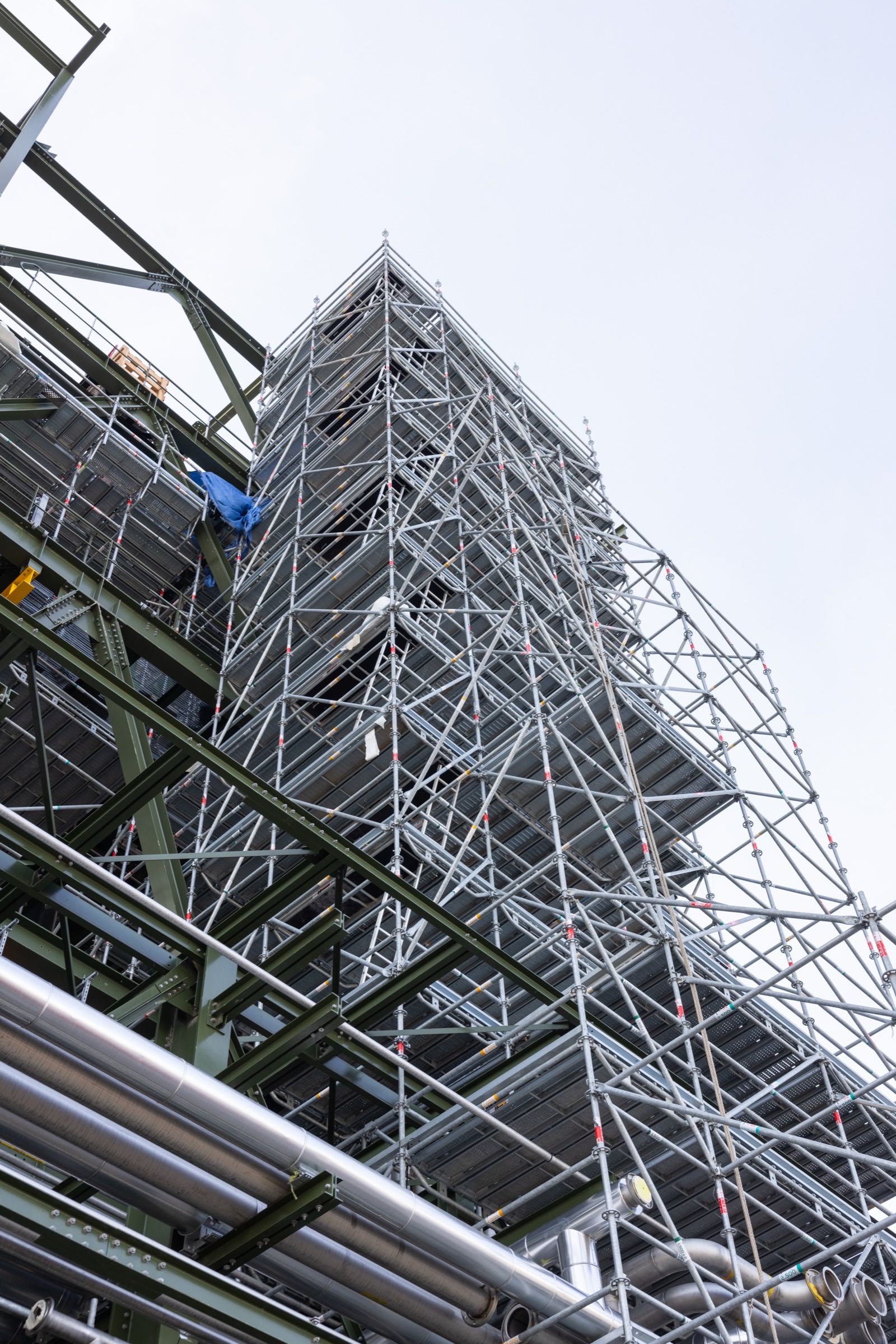 Vue en contre-plongée d'un échafaudage industriel soulignant la verticalité et la complexité
