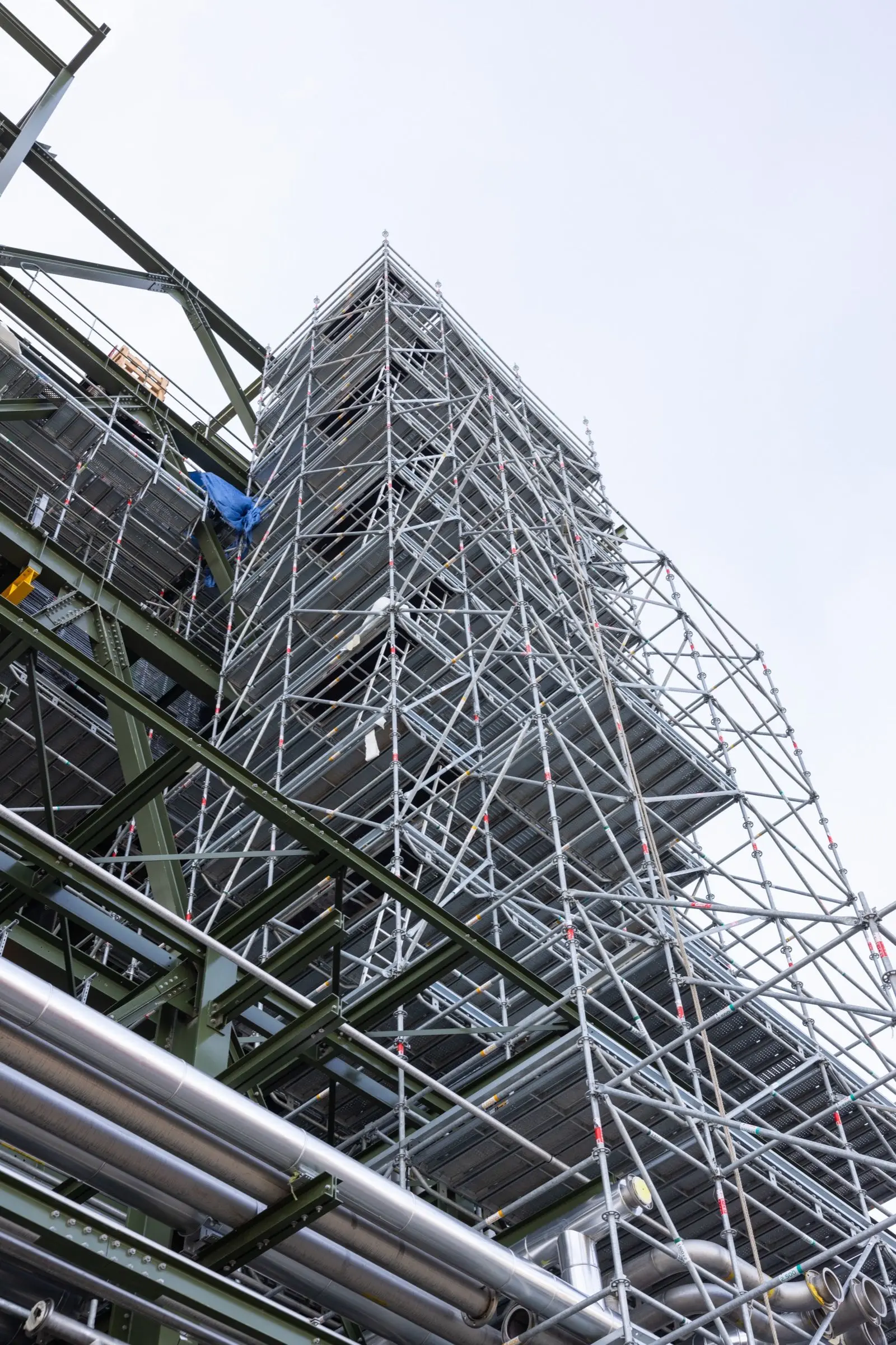 Vue en contre-plongée d'un échafaudage industriel soulignant la verticalité et la complexité