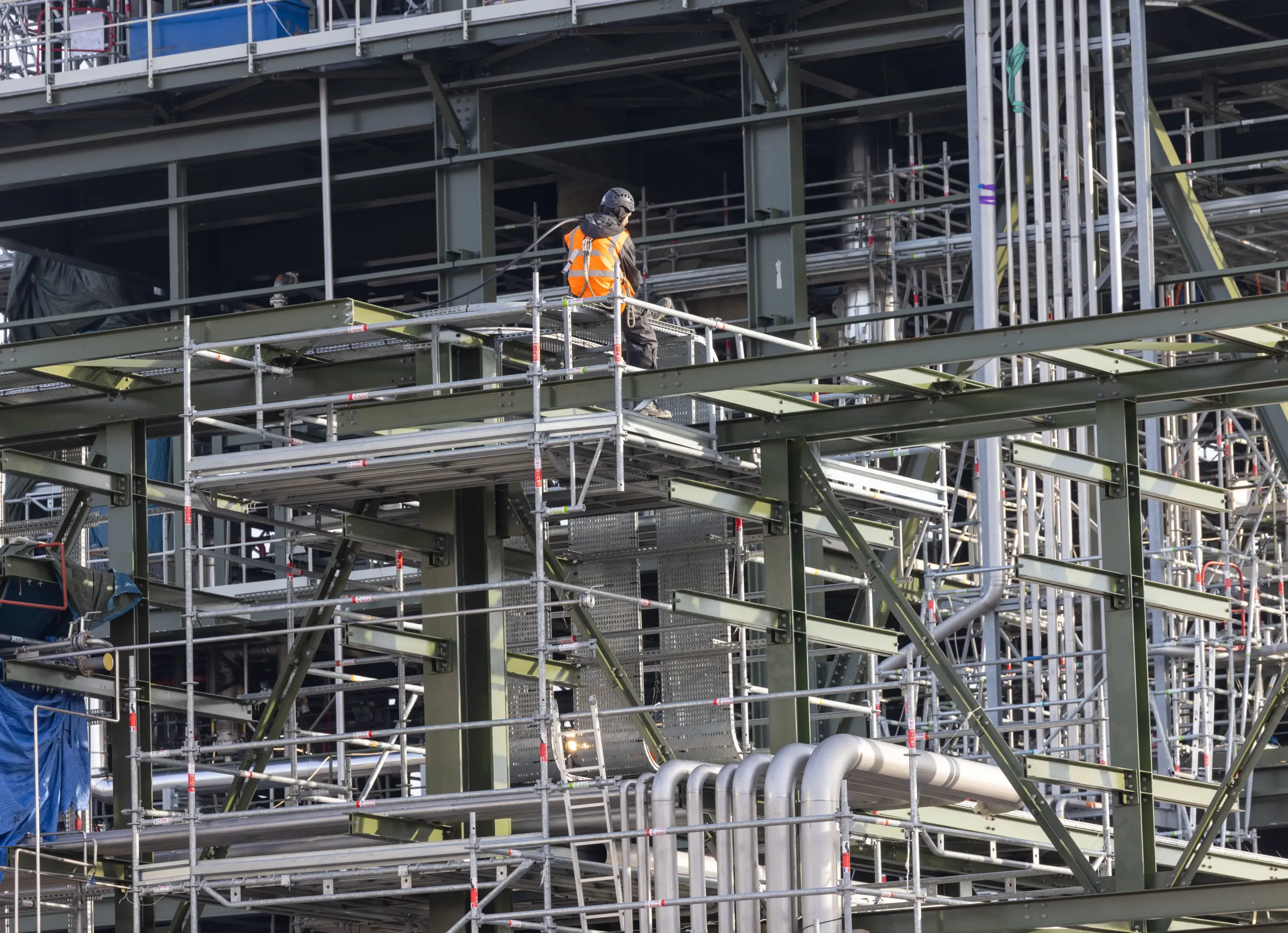 Équipe de monteurs qualifiés travaillant en grande hauteur sur une structure industrielle